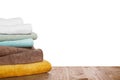 Soft colorful terry towels on wooden table against white background, space for text