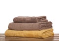 Soft colorful terry towels on wooden table against white background