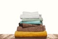 Soft colorful terry towels on wooden table against white background