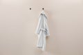 Soft comfortable bathrobe hanging on wall