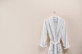 Soft comfortable bathrobe hanging on wall, space for text Royalty Free Stock Photo