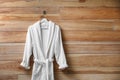 Soft comfortable bathrobe hanging on wall, space for text Royalty Free Stock Photo