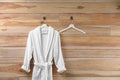 Soft comfortable bathrobe hanging on wall, space for text Royalty Free Stock Photo
