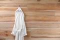 Soft comfortable bathrobe hanging on wall, space for text Royalty Free Stock Photo