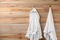 Soft comfortable bathrobe and towel hanging on wall. Space for text Royalty Free Stock Photo