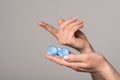 Soft contact lens and blue container in female hands on gray background Royalty Free Stock Photo