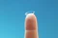 Soft contact lens on female finger on blue background Royalty Free Stock Photo