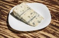 Soft and creamy. Blue cheese food. Piece of cheese on plate. Roquefort cheese. Gorgonzola cheese. Italian or danish