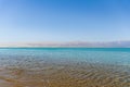 Soft crystal clear water in the sea at sunny day with mountains against the background. Dead sea coastline.