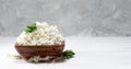 Soft curd natural healthy food, wholesome diet food. Cottage cheese in a traditional wooden bowl with mint leaves on a white