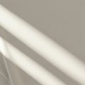 Soft, diagonal shadow lines stretch across a smooth, beige fabric surface, creating a Royalty Free Stock Photo