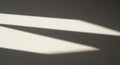 Soft diagonal shadows create triangular patterns on a light gray surface, produci Royalty Free Stock Photo