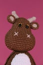 Soft DIY toy made of natural cotton and wool. Cute little cow crocheted, handmade art. Close-up portrait. Amigurumi one Royalty Free Stock Photo