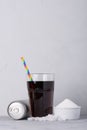 Soft drink can and glass with and crystal sugar on table