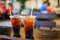 Soft drink with ice and white tube in plastic glass set on table Royalty Free Stock Photo