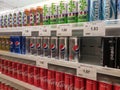 Soft drinks in cans are displayed on a shelf for sale in a large supermarket. Royalty Free Stock Photo