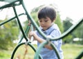 Soft focus of active kid climbing rope in the playground, High key light portrait Child enjoying activity in a climbing adventure Royalty Free Stock Photo