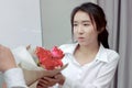 Soft focus of attractive young Asian woman accepting a bouquet of red roses from boyfriend in office on valentine`s day. Love and Royalty Free Stock Photo