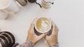 Soft focus blur Hand holding cup of hot latte art coffee homemade with equipment, percolator tool brewing on the table at kitchen Royalty Free Stock Photo