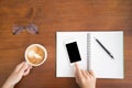 Soft focus,blur.Top view woman hands holding cup of coffee and touching mobile phone with blank copy space for your text message Royalty Free Stock Photo