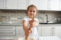 Soft focus on blurred beautiful smiling girl hands holding wooden spoon and kneading dough. Children cooking Royalty Free Stock Photo