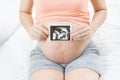 Soft focus and blurry of happy pregnant woman lying on bed at home holding and showing ultrasound scan photos. Pregnancy, Fetal