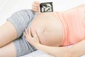 Soft focus and blurry of happy pregnant woman lying on bed at home holding and showing ultrasound scan photos. Pregnancy, Fetal