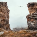 Soft focus. Dangerous gorge, a cliff between two rocks. Dramatic fog among giants rocky mountains. Ghostly atmospheric view to big Royalty Free Stock Photo