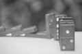 Soft Focus - Domino Effect Concept : Row of black dominoes on white floor and bokeh background. Royalty Free Stock Photo