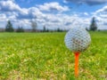 Soft focus f a grungy golf ball on a tee at a grassy field in Venango, Pennsylvania