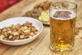 Soft focus of a glass of a foamy craft beer with blurry food in the background on a wooden table