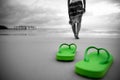 Soft focus on Green flip flop with sad woman walking