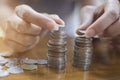 Soft focus of hand of Asian woman putting a silver coin on top of two pile for stacking Royalty Free Stock Photo