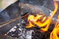 Soft focus of metal tongs fixing burning wood in a  fire pit Royalty Free Stock Photo