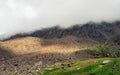 Panoramic wonderful minimalist landscape with big mountain peaks above low clouds, fog over the mountain slopes in the distance, Royalty Free Stock Photo