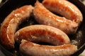 Soft focus photo. Fried sausages on the pan. Unhealthy breakfast. English and German style cuisine