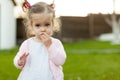 Soft focus photo of little curly girl with two tails walking in the backyard on the green grass Royalty Free Stock Photo