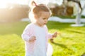 Soft focus photo of little curly girl with two tails walking in the backyard on the green grass Royalty Free Stock Photo