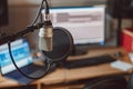 Soft focus on a professional microphone on the blurred background of laptop and screen monitor in sound recording studio Royalty Free Stock Photo