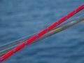 Soft focus of a red boat rope stretched across a boat against blue waters Royalty Free Stock Photo