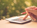 Soft focus retro woman hand working with calculator and holding red pencil Royalty Free Stock Photo