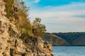 Soft focus scenic view rocky stones on hill above lake water shore line with brown yellow and green foliage and late summer season Royalty Free Stock Photo