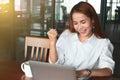 Soft focus of smiling young Asian businesswoman raising hands in office. Successful business woman concept Royalty Free Stock Photo