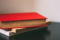 Soft focus of a stack of books with a thick red book on top against a blurry background Royalty Free Stock Photo