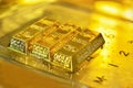 Soft focus of three gold bars on the transparent calculator with the golden reflect light.