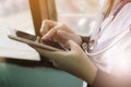 Soft focus of woman doctor touching blank screen for work on modern smart phone in the consultation in the workplace hospital