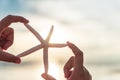 Soft focus on woman hand holding starfish over sea and Sandy Royalty Free Stock Photo