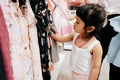 Soft Focus of a 4-5 Years Old Child Choosing her own Dresses from Kids Cloth Rack in Clothing Shop