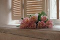A soft focused bouquet of flowers on a window sill, dull light