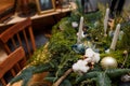 Soft focused close up shot of rustic style Christmas festive table, fresh thuja, fir, cotton branches bouquet, white candles. Eco- Royalty Free Stock Photo